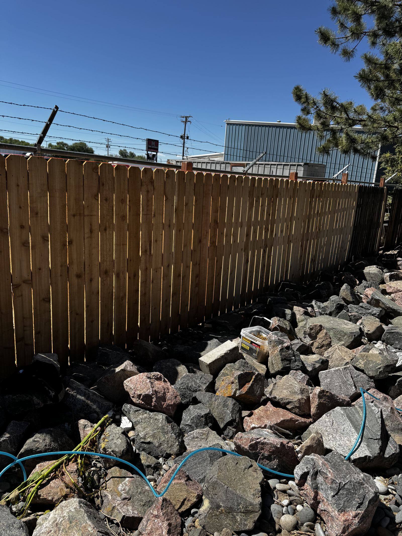 New cedar privacy fence built along a rock border