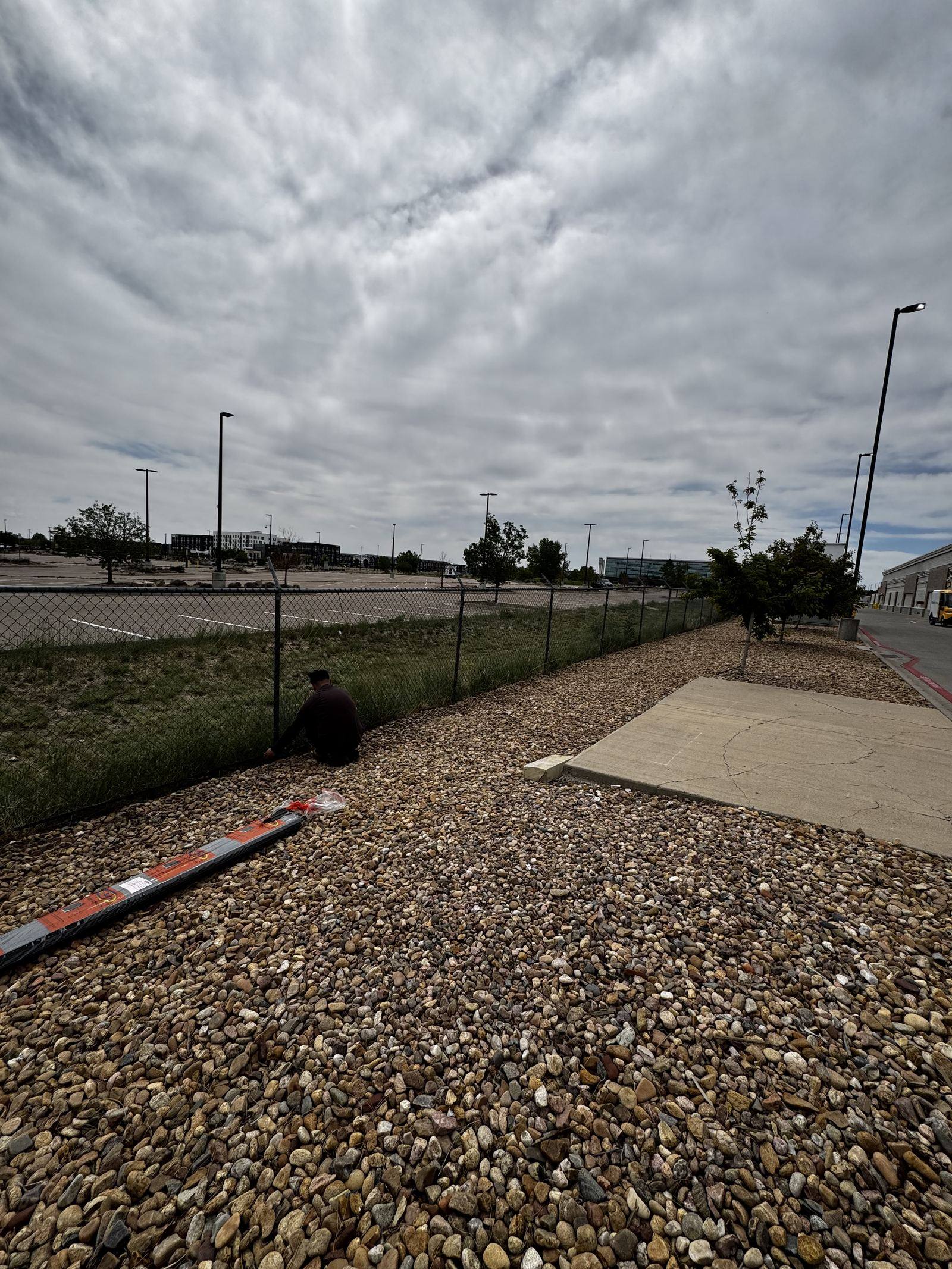 Crew member working a chain-link fence line